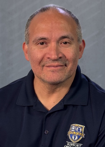 Headshot of a smiling man wearing a blue URochester polo shirt. 