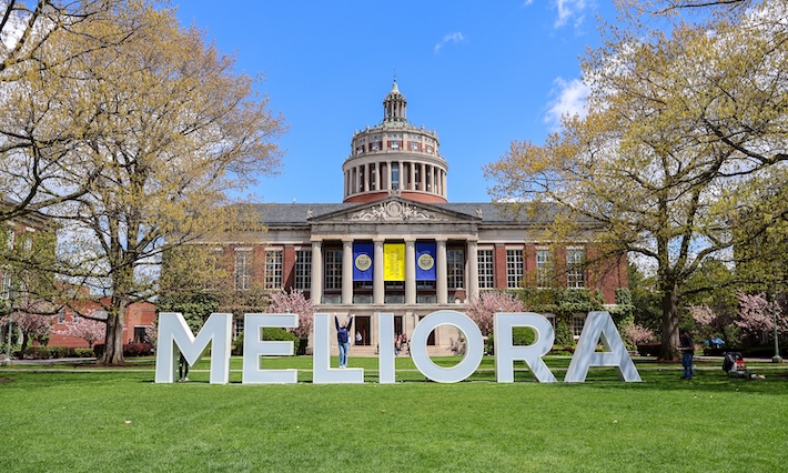Large letters spelling out MELIORA span the green quad. 