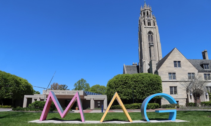 External shot of museum with large letters spelling out MAG. Blue skies are in the background. 