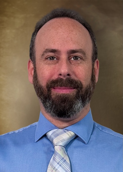 Man in a blue button down shirt and tie. 