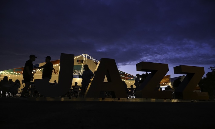 Large letters spelling the word jazz lit from behind at night. 