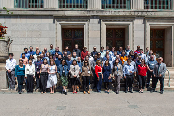 Dozens of members of the Center for Matter at Atomic Pressure gathers on the steps of the Rush Rhees Library.
