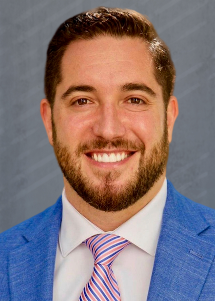 Smiling man in blue suit and striped tie.