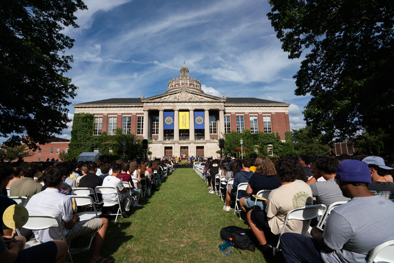 New students sit on chairs in the Eastman Quadrangle in front of Rush Rhees Library during Convocation.