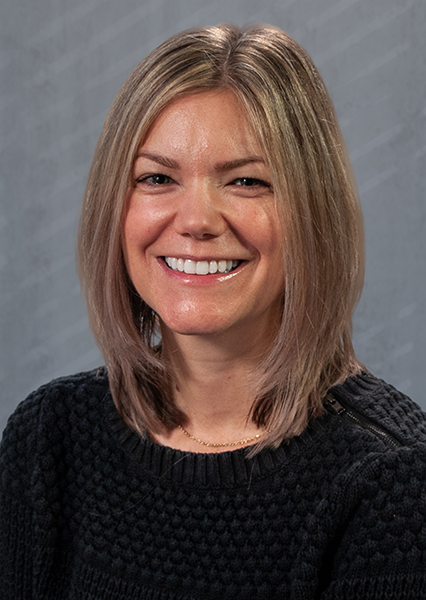 smiling woman wearing a black top.