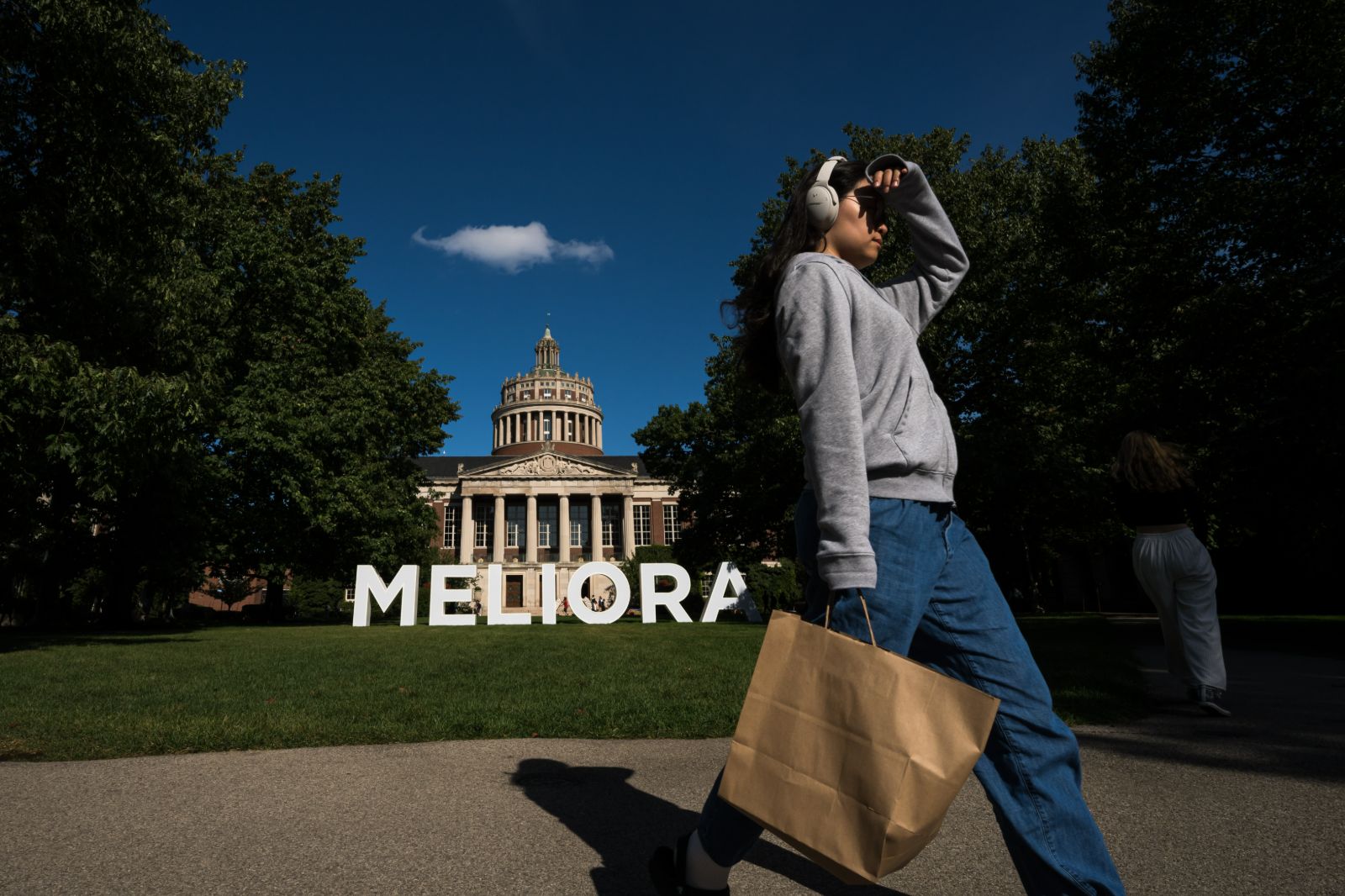 A woman walks by the Meliora Building on the University of Rochester campus in Ann Arbor, Michigan.