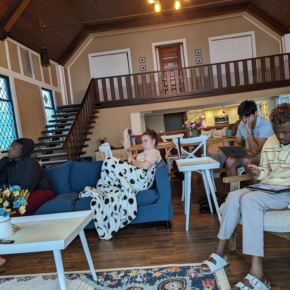 Four people in the living room working.