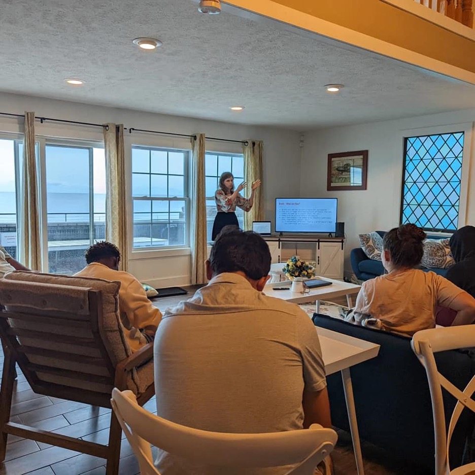 A group of students watching someone give a presentation.