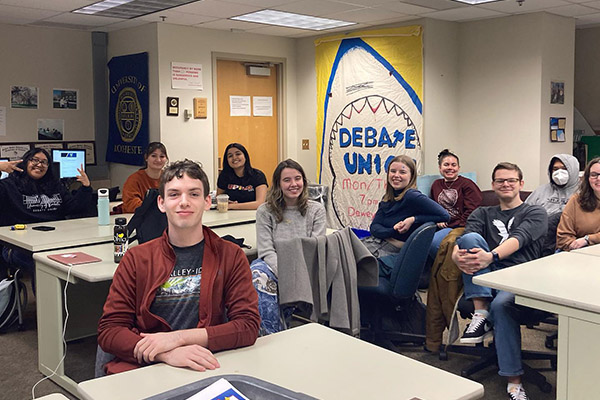 New debaters pose for a picture at the general interest meeting in the debate office.