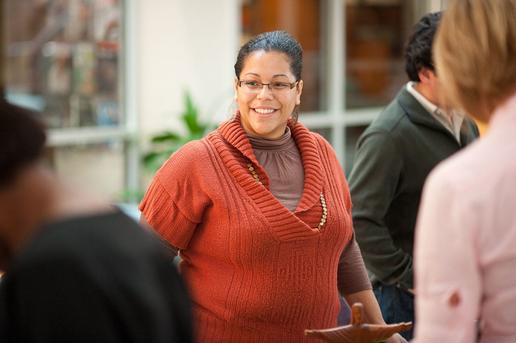 woman smiling, behind a table at a cultural fair