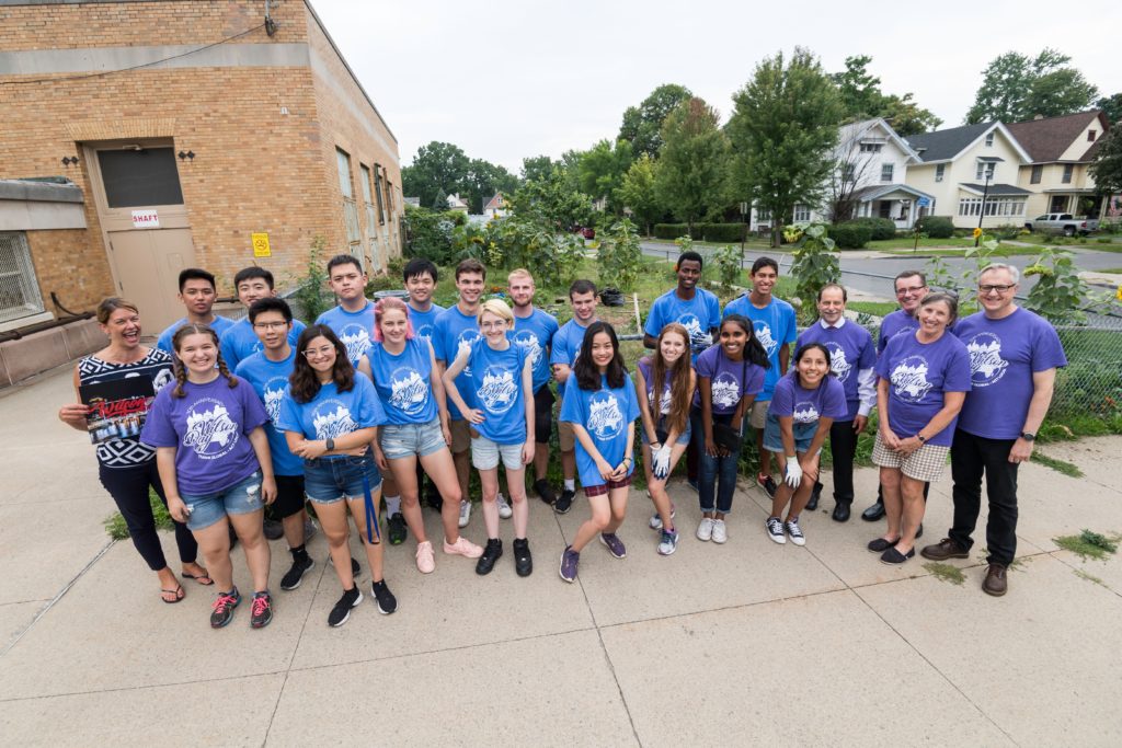 students pose for a photo next to the community garden at Wilson Magnet High School with Wilson and UR leadership