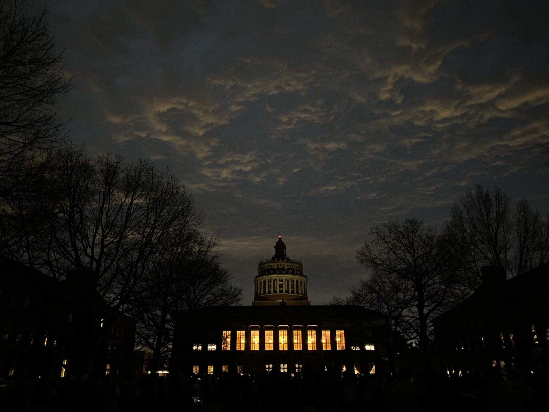 A dark Eastman Quad and lit up Rush Rhees Library during the eclipse