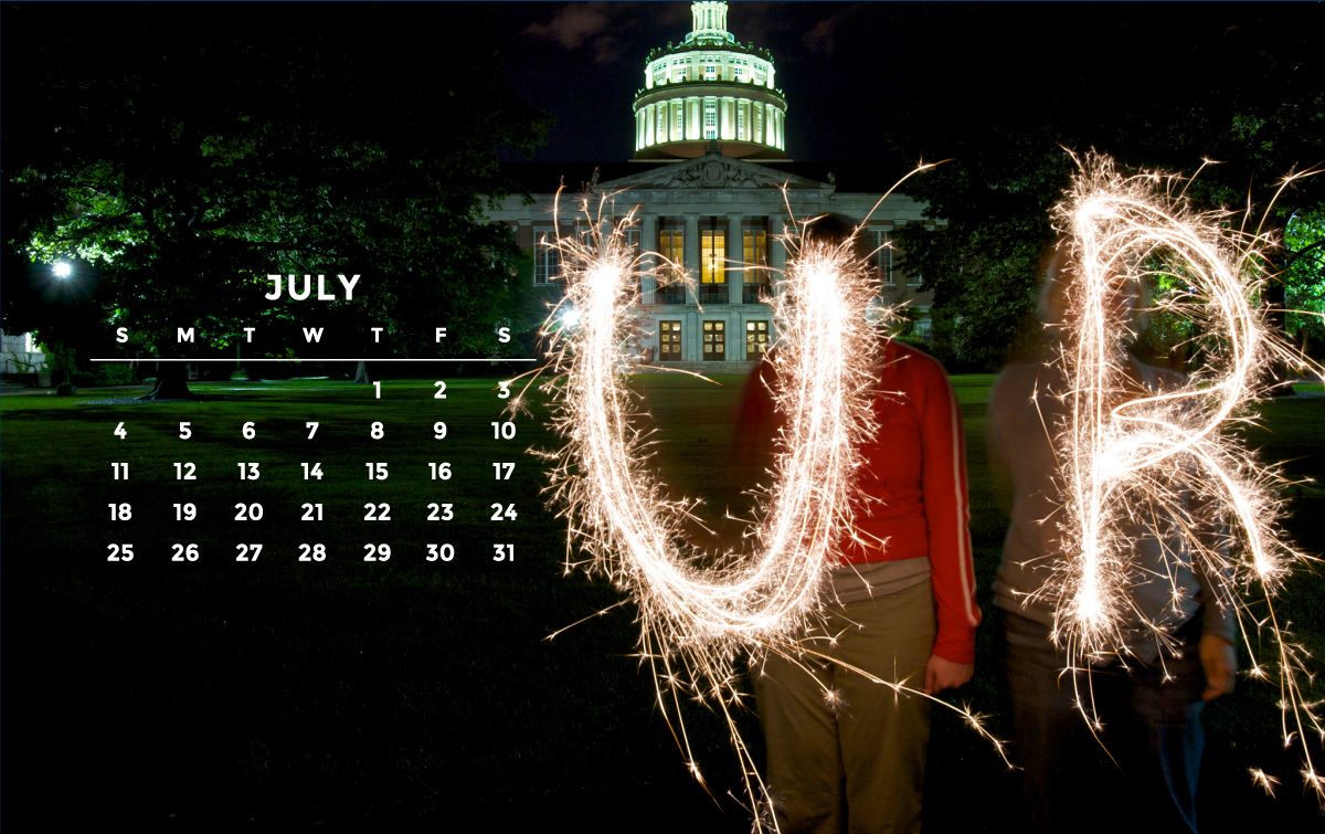 Photo of two students using sparklers on the University of Rochester River campus.