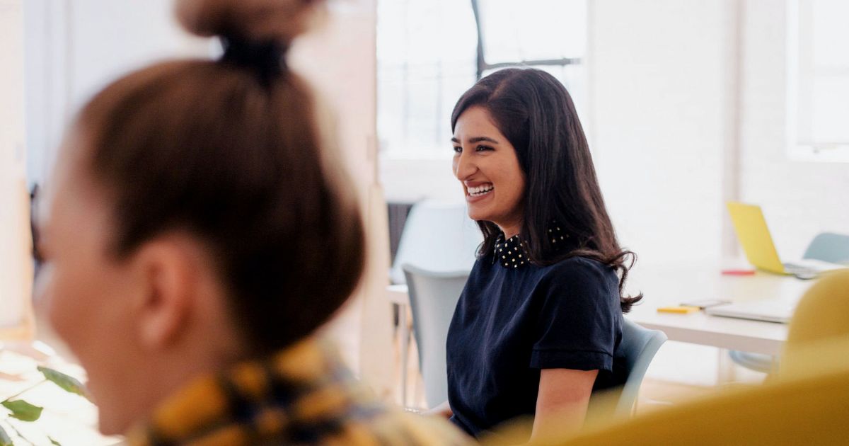 Feature image Young professional sitting at a meeting table.