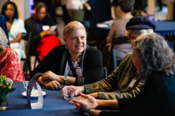 Guests gather and converse at a round table during the George Eastman Circle Faculty & Staff Reception in Rochester, NY.