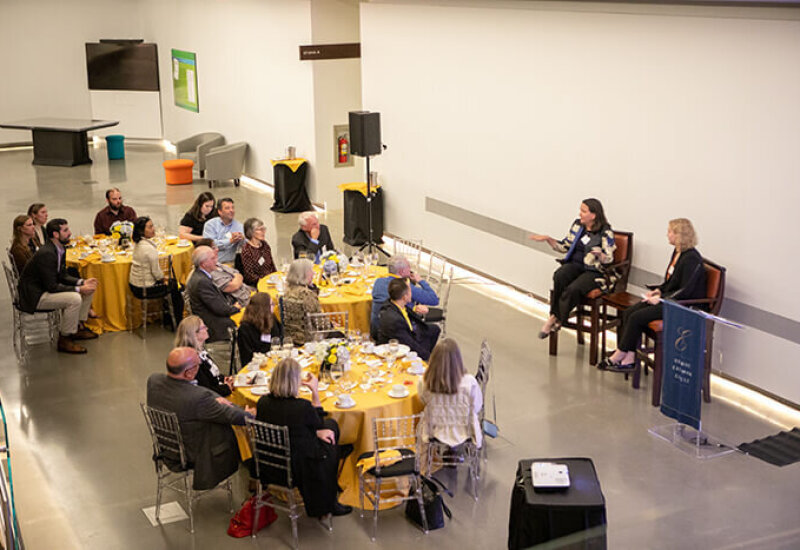 overview image of people mingling at tables