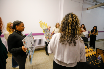 Group of people having a conversation holding a posterboard