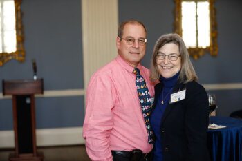 A man and woman pose for a photo at the George Eastman Circle Faculty & Staff Reception held on March 30, 2023 within Rochester New York.