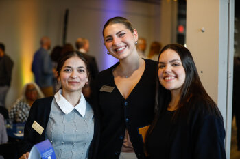 Three student representatives smile together at the George Eastman Circle Faculty & Staff Reception in Rochester, NY.