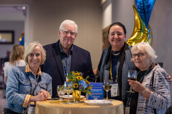 Group photo of 4 people around the table