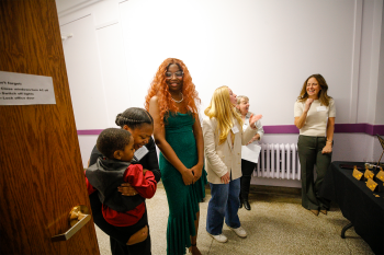 A hybrid of adults and children standing in a room