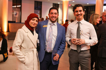 A group of three attendees pose for a photo