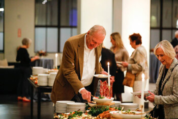 Attendees serving themselves food at the George Eastman Circle Annual Member Dinner.