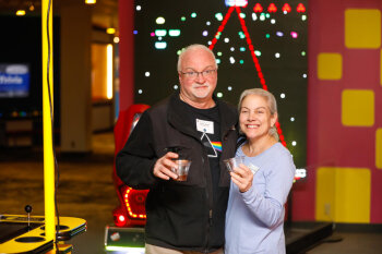 A man and woman pose for a photo at the George Eastman Circle Family Celebration, held on April 27, 2023 within Rochester New York.