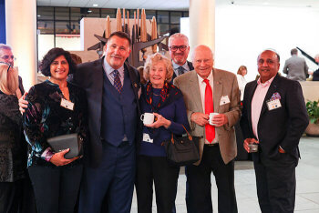 A group of six attendees pose for a photo
