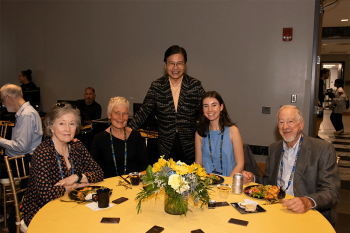 5 people seated at a table posing for a photo