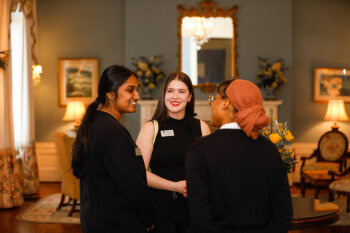A candid photo of three women conversing at the George Eastman Circle Faculty & Staff Reception held on March 30, 2023 within Rochester New York.