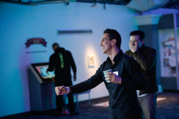 A candid photo of two men whom are excited as they compete at a game at the George Eastman Circle Family Celebration, held on April 27, 2023 within Rochester New York.