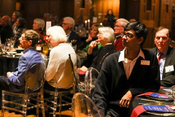 A group of attendees are seated listening attentively