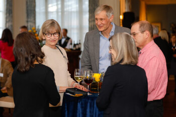 A candid group photo of five individuals conversing at the George Eastman Circle Faculty & Staff Reception held on March 30, 2023 within Rochester New York.