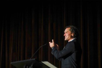 A man speaking at a lecturn