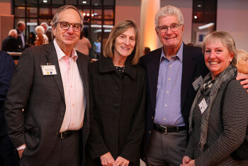 A group of four attendees pose for a photo