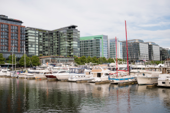 boats at a dock with buildings in the background