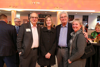 A group of four attendees pose for a photo