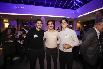 3 men posing for a photo at reception in MAG lobby