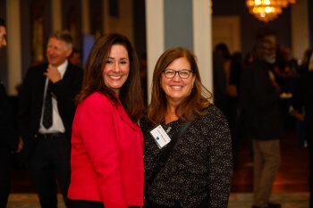 Two females pose for a photo at the George Eastman Circle Faculty & Staff Reception held on March 30, 2023 within Rochester New York.