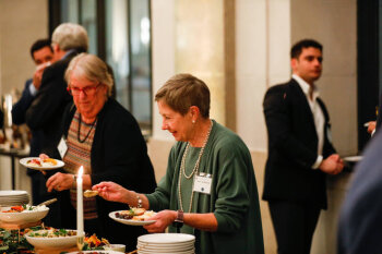 Attendees serving themselves food at the George Eastman Circle Annual Member Dinner.