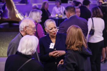 Candid photo of 4 people having a convseration at reception in MAG lobby