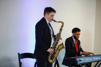 A saxophonist and keyboardist perform live jazz at the George Eastman Circle Faculty & Staff Reception in Rochester, NY.