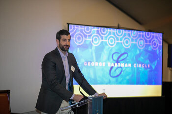 man at podium in front of screen
