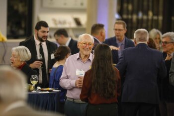 Photo of a crowd of people and a man talking to a woman