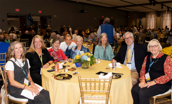 Group of people seated at table posing for a photo