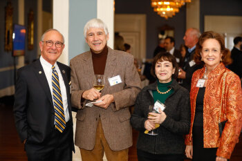 Two men and two women pose for a photo at the George Eastman Circle Faculty & Staff Reception held on March 30, 2023 within Rochester New York.