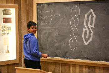 A boy in front of a blackboard