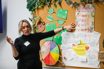 A woman presenting a bulletin board with documents on it