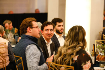 A candid photo of attendees talking at a table at the George Eastman Circle Annual Member Dinner.